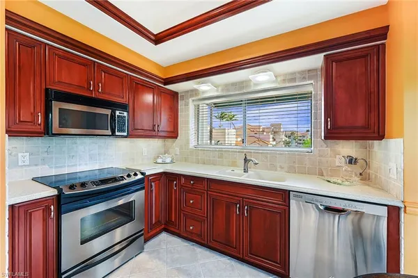 a kitchen with granite countertop stainless steel appliances a sink stove and microwave