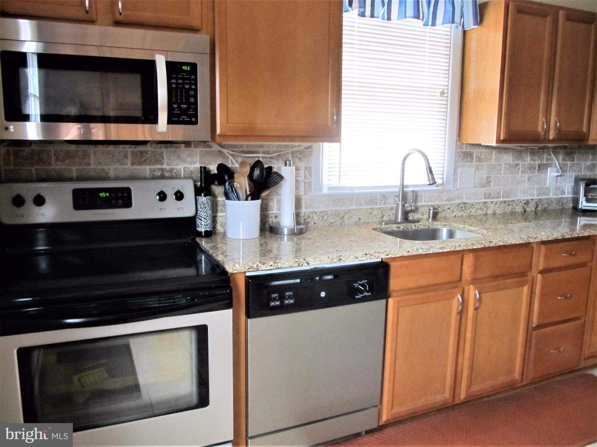 558 Fairmount Road Linthicum Heights, MD 21090 - Photo 6 of 30 a kitchen with stainless steel appliances granite countertop a stove microwave and sink