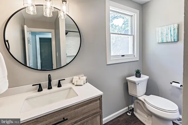 a bathroom with a sink mirror and toilet