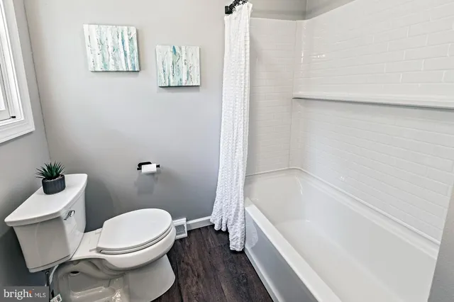 a white toilet sitting next to a bath tub