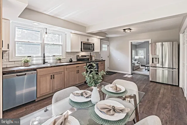 a kitchen with stainless steel appliances granite countertop a dining table and chairs