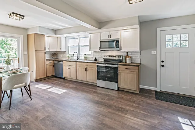 a kitchen with stainless steel appliances granite countertop a stove top oven a sink dishwasher and a refrigerator