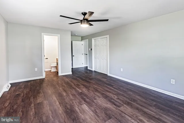 a view of a livingroom with wooden floor and a ceiling fan