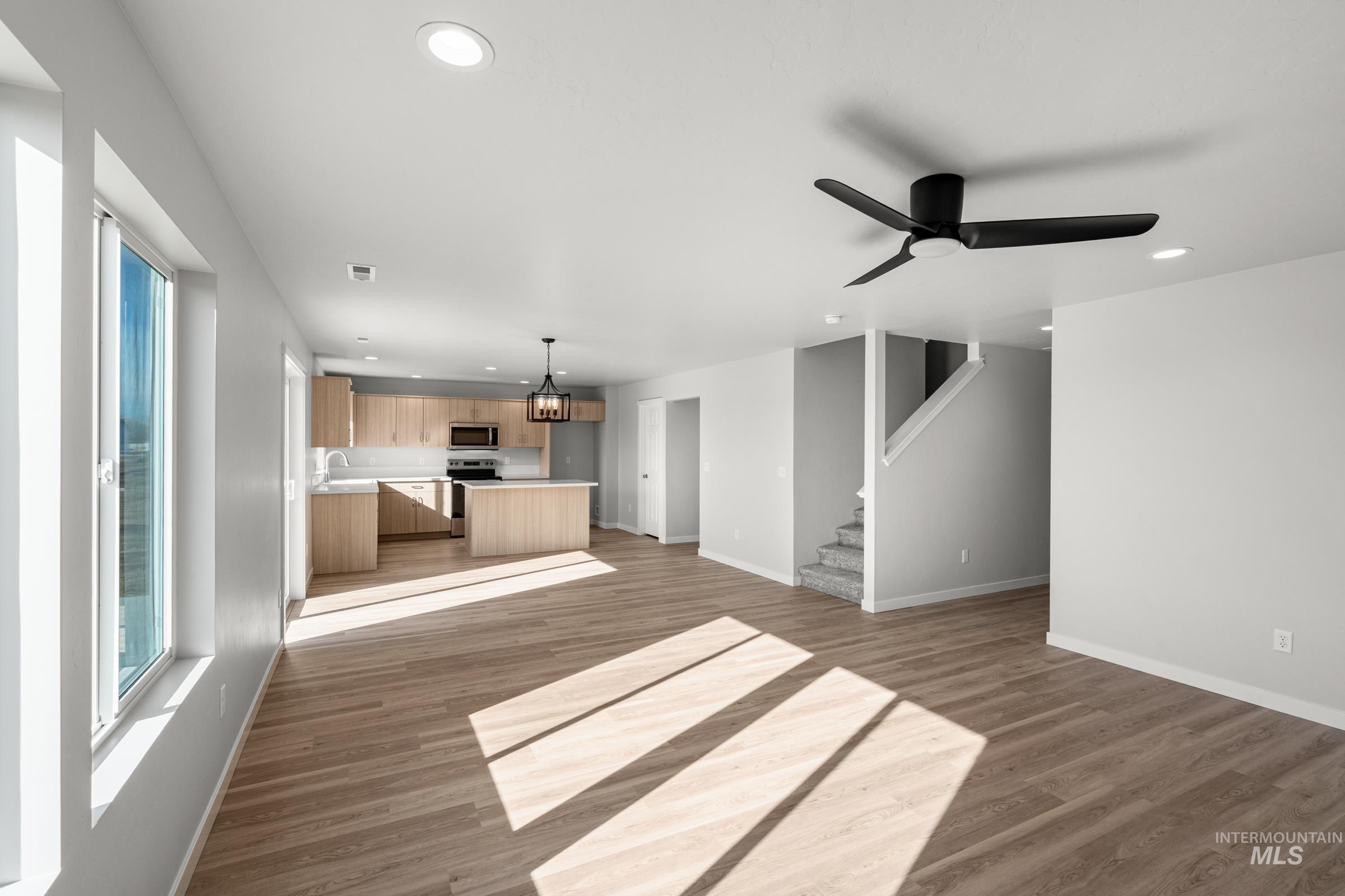 1687 Dyer Street Middleton, ID 83644 - Photo 11 of 28 Unfurnished living room featuring suspended lighting, dark wood-type flooring, and ceiling fan