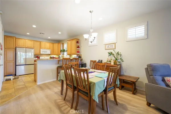 a dining room filled a chandelier a glass table and chairs