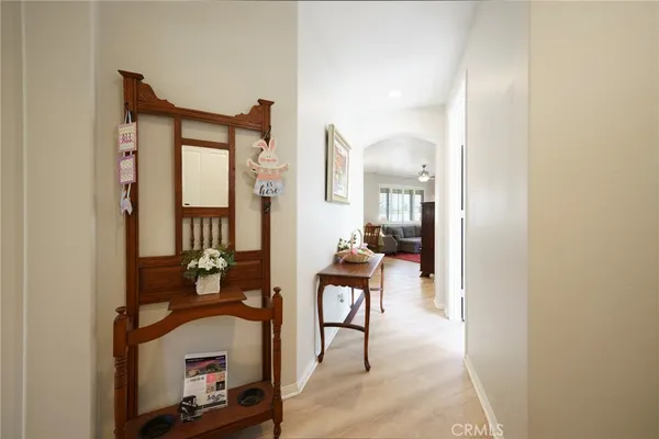 a view of a hallway with wooden floor and a living room