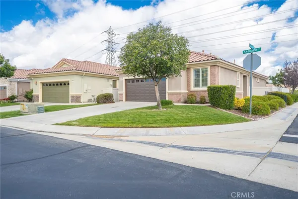 a view of house with a yard and potted plants