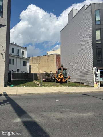 a view of a building with car parked on the road