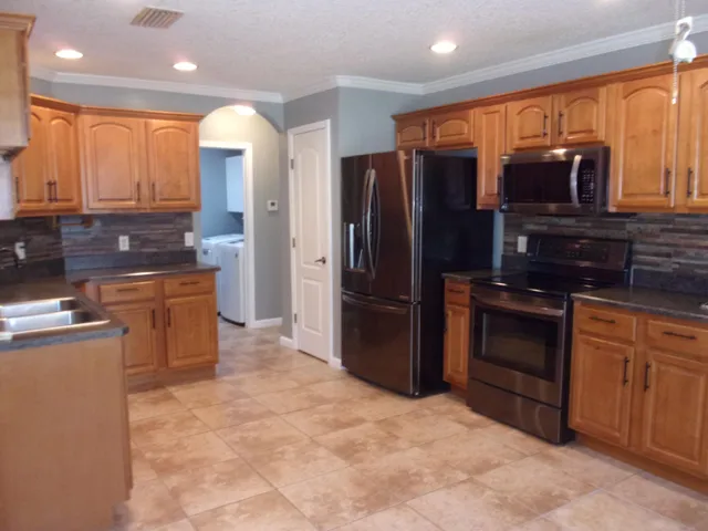 a kitchen with stainless steel appliances granite countertop a refrigerator and a stove