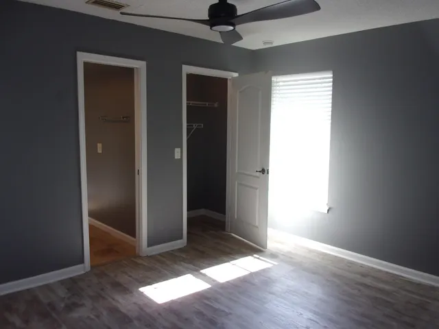a view of an empty room with wooden floor