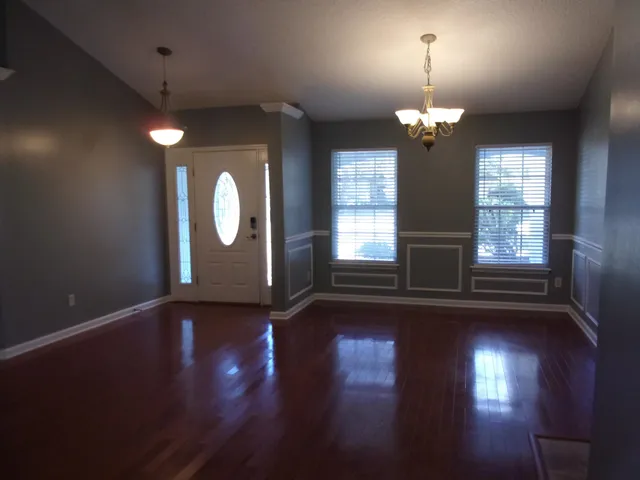 a view of a livingroom with wooden floor fireplace and window