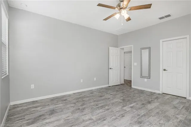 a view of an empty room and chandelier fan