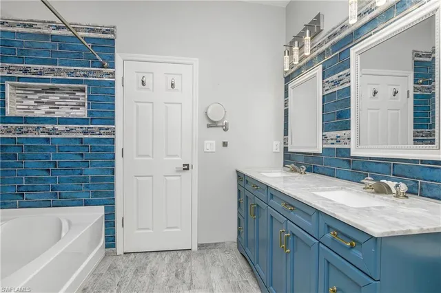 a bathroom with a granite countertop bathtub sink vanity and mirror