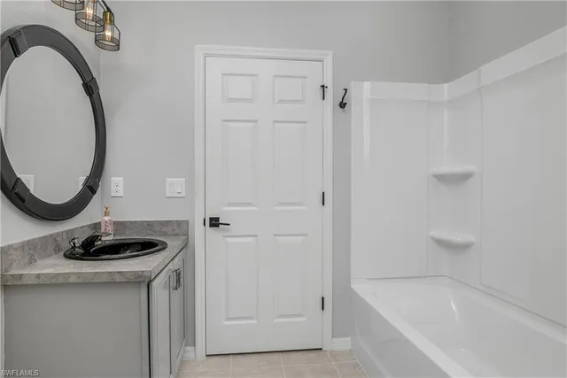a bathroom with a granite countertop sink a mirror and shower