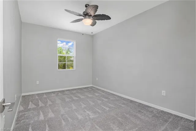 an empty room with a window and a fan