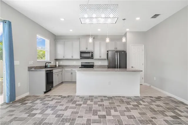 a kitchen with a sink a counter top space cabinets and stainless steel appliances
