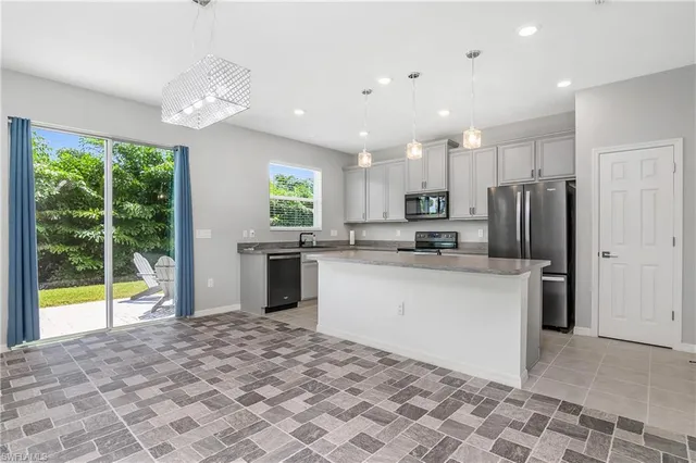 a kitchen with stainless steel appliances granite countertop a refrigerator sink and stove