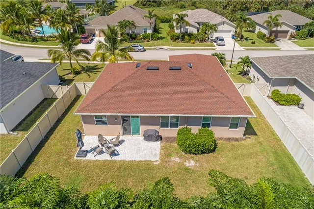 an aerial view of a house with swimming pool and large trees