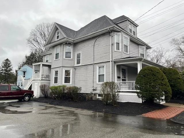 a view of a white house with large windows and a small yard