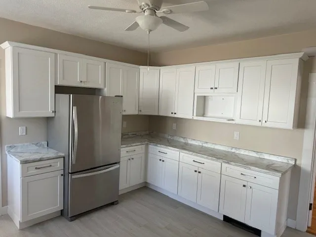 a kitchen with white cabinets and white appliances