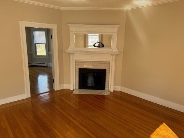 7 Lowell Street, Unit A Woburn, MA 01801 - Photo 8 of 17 a view of an empty room with wooden floor and a fireplace