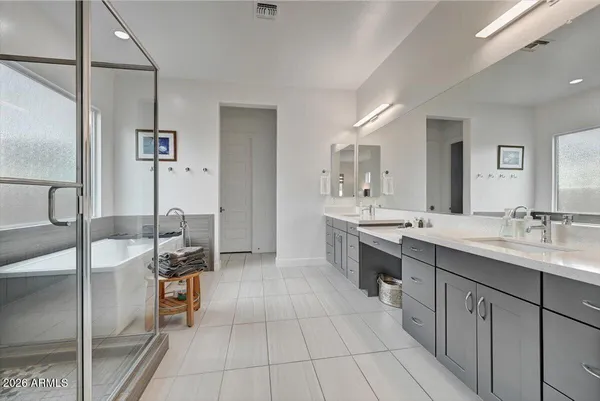 a large bathroom with a double vanity sink a mirror and a shower