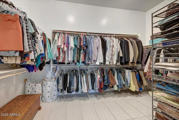 a view of walk in closet with clothes and shoes