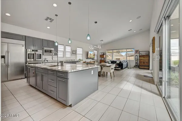 a kitchen with stainless steel appliances granite countertop a sink counter space cabinets and a large window