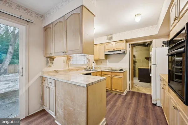 a kitchen with stainless steel appliances granite countertop a sink and cabinets with wooden floor