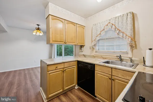 a dining room with furniture a chandelier and wooden floor