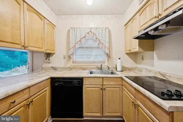 a kitchen with stainless steel appliances a stove top oven and a large window