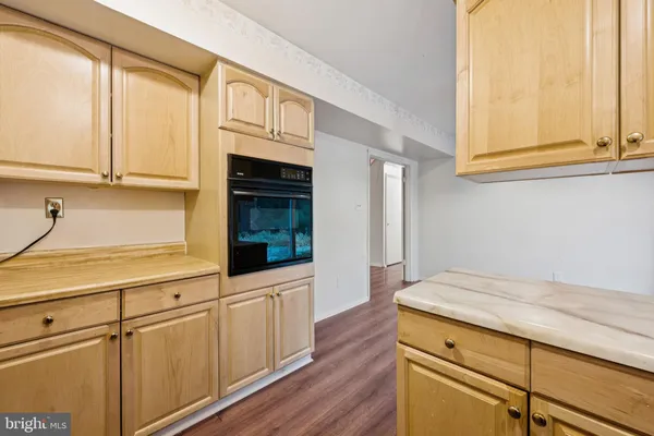 a kitchen with stainless steel appliances a sink cabinets and a wooden floor