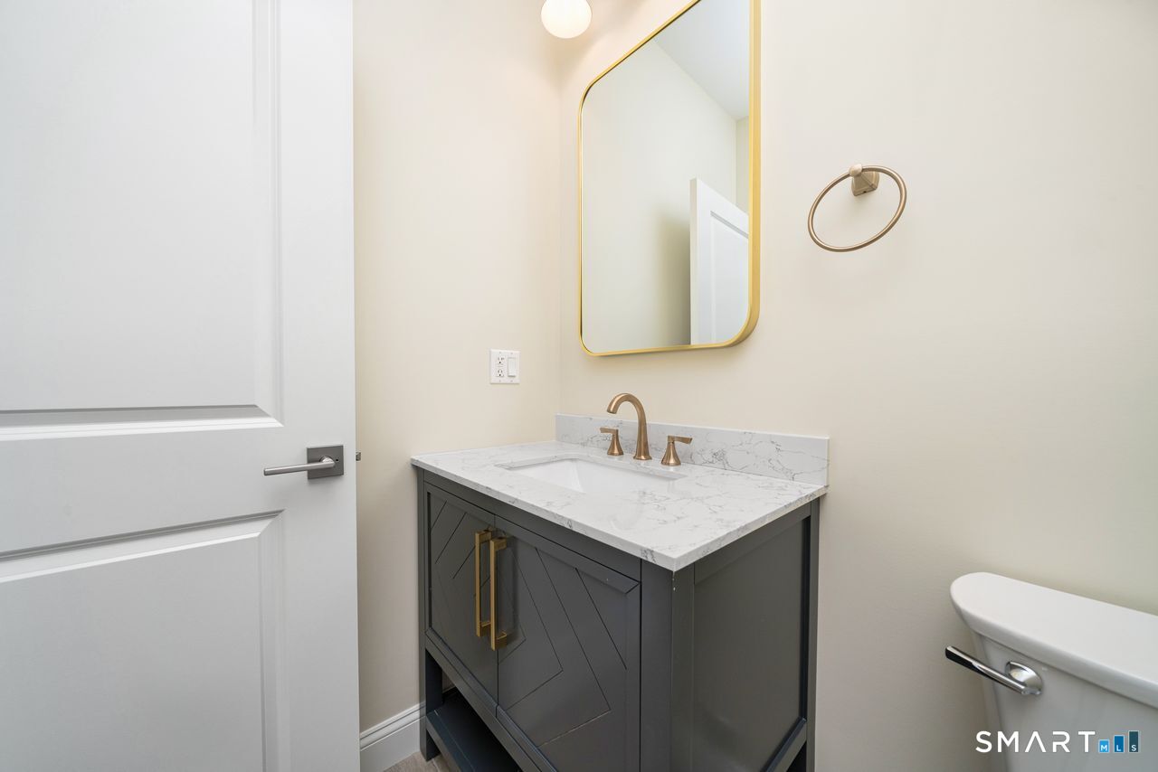 a bathroom with a sink a toilet and a mirror
