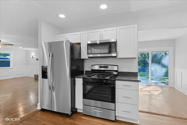 a kitchen with stainless steel appliances a stove microwave and refrigerator