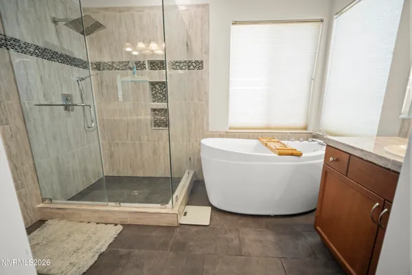 a bathroom with a granite countertop sink mirror vanity and bathtub