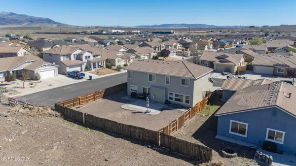 an aerial view of a house with a mountain