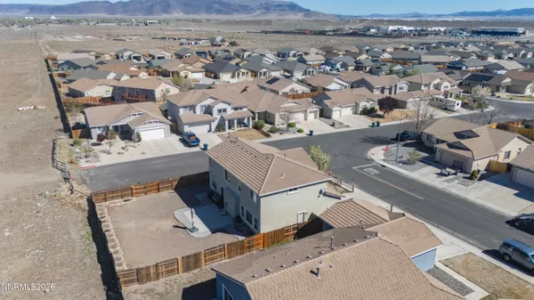 an aerial view of a house with a mountain