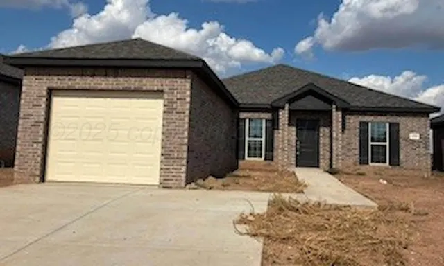a view of a house with a small yard and potted plants