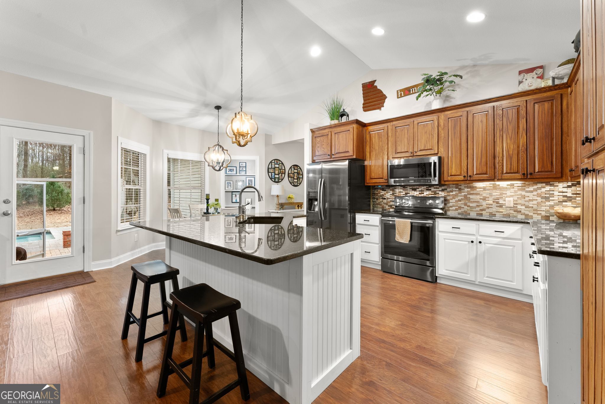 96 Magnolia Place Commerce, GA 30529 - Photo 16 of 58 a kitchen with stainless steel appliances kitchen island granite countertop a stove a sink and a refrigerator with wooden floor