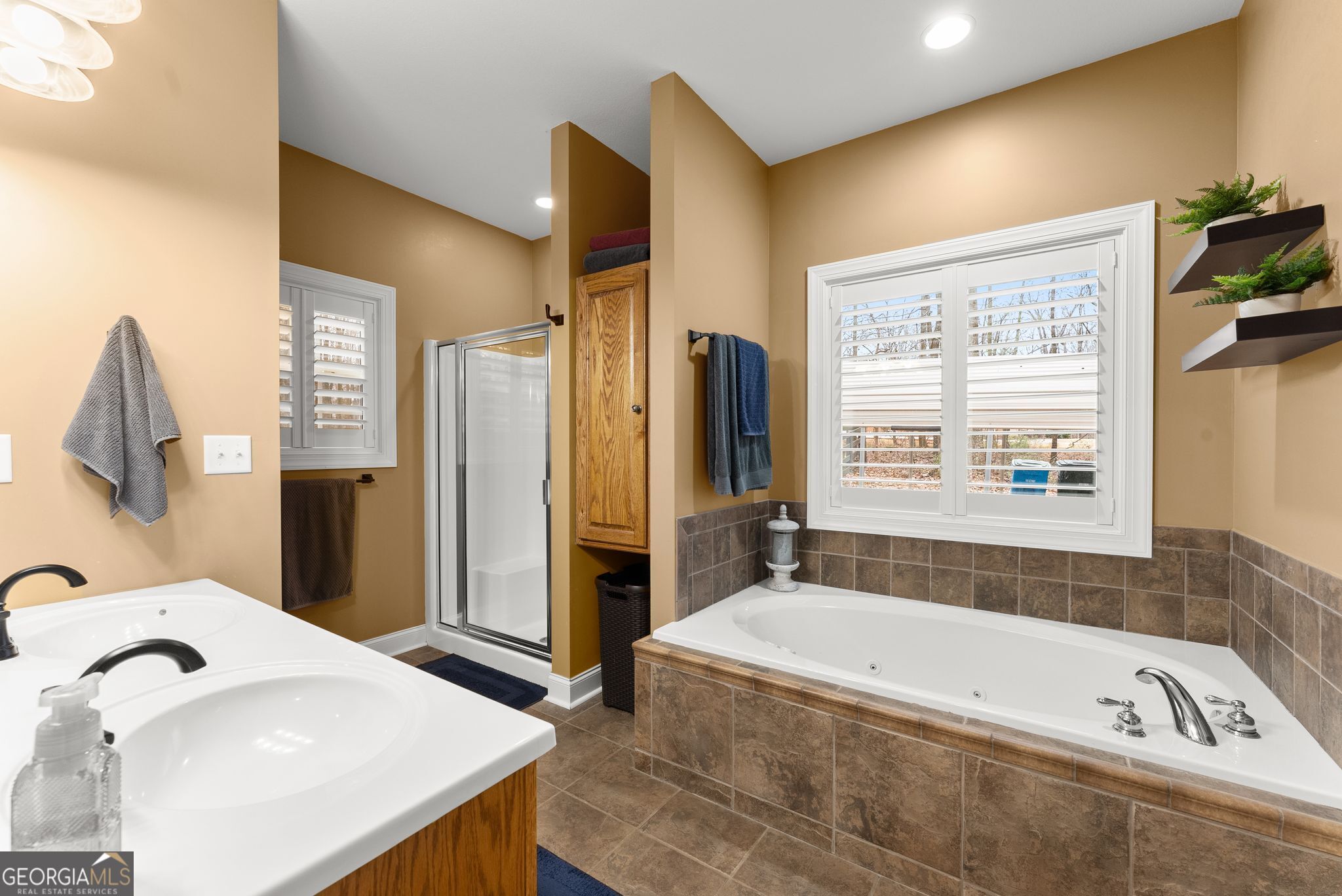 96 Magnolia Place Commerce, GA 30529 - Photo 23 of 58 a bathroom with a tub a sink and a large mirror