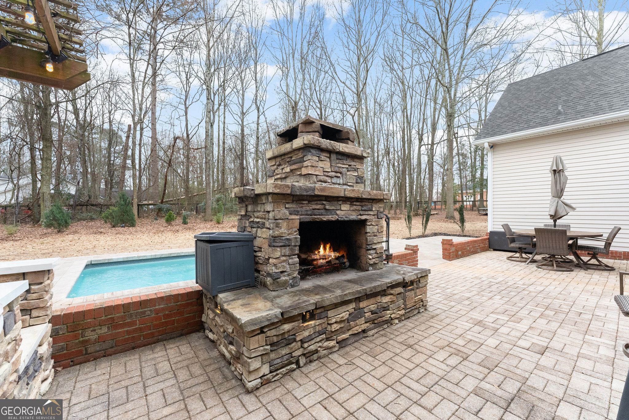 96 Magnolia Place Commerce, GA 30529 - Photo 38 of 58 a living room with a couch a fire pit and a large tree