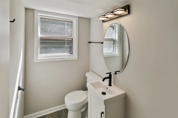 a bathroom with a toilet sink and mirror