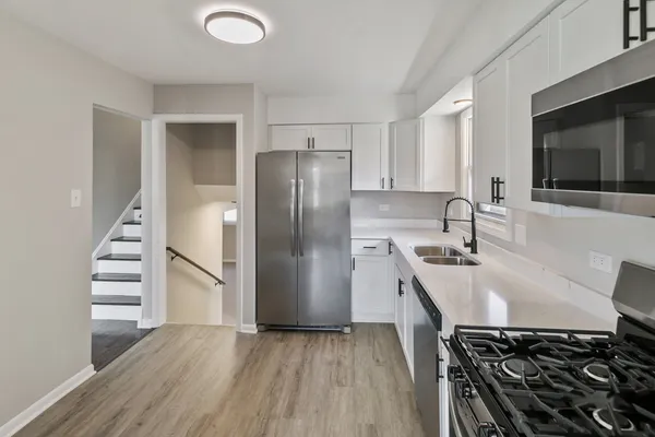a kitchen with stainless steel appliances a refrigerator and a stove top oven