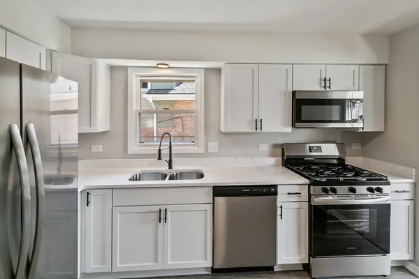 a kitchen with white cabinets stainless steel appliances and sink
