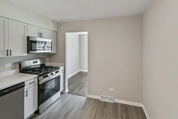 a kitchen with wooden floor and stainless steel appliances