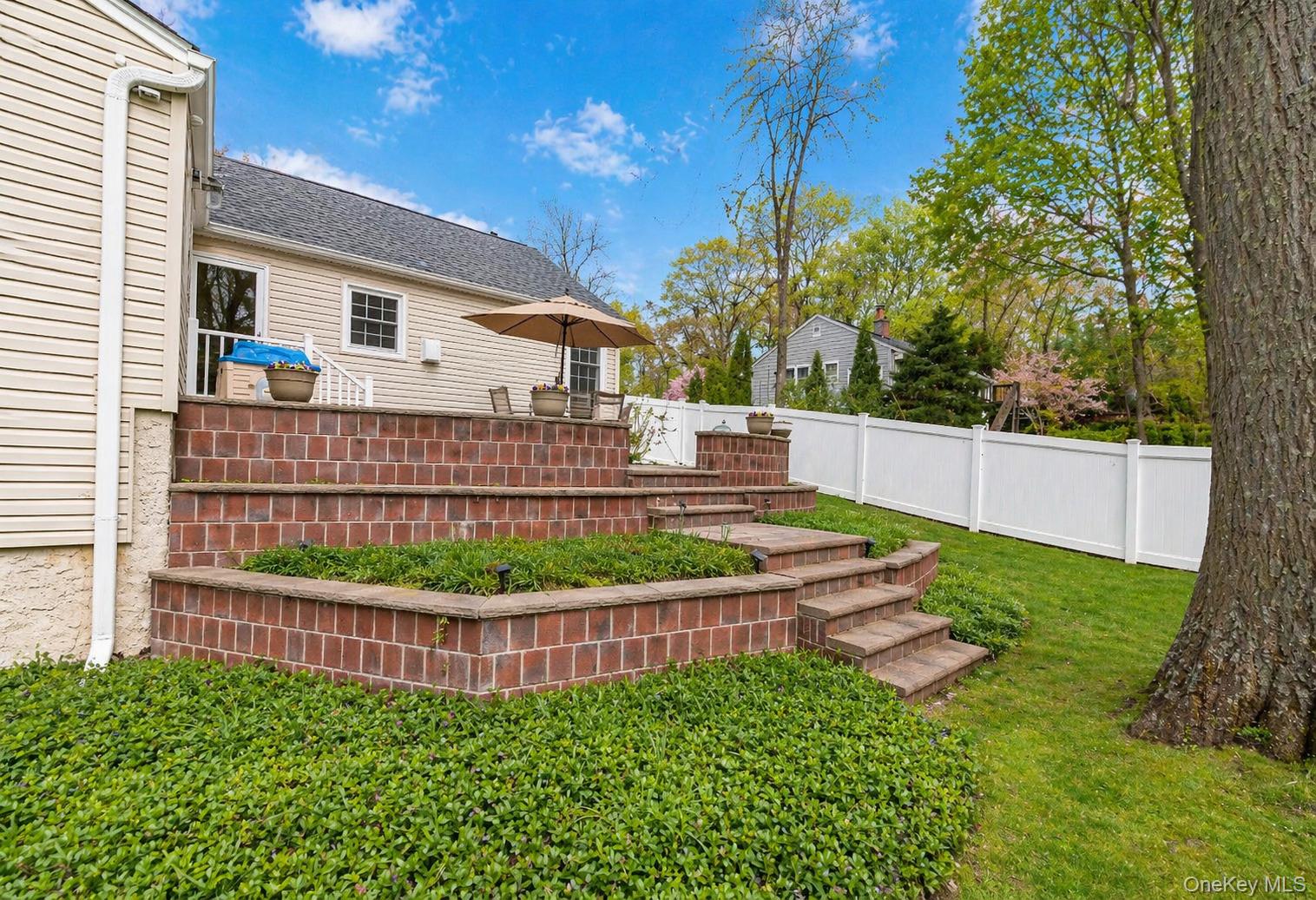 6 Huyler Road Setauket, NY 11733 - Photo 24 of 27 a view of a yard with plants and wooden fence