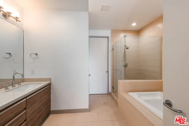 a bathroom with a tub sink shower and mirror