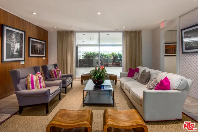 a living room with furniture kitchen and a large window