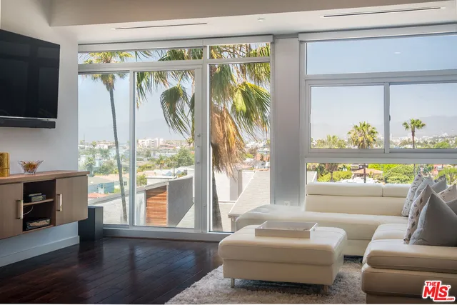 a living room with furniture a flat screen tv and a large window