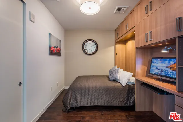 a bedroom with a bed and a wall painting